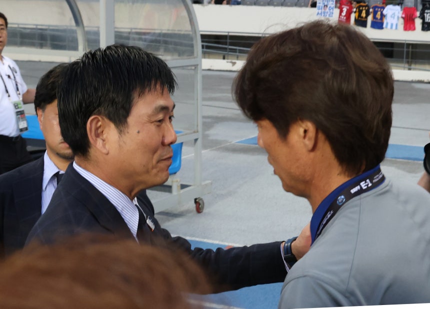 東アジアカップ日韓戦の試合前に挨拶を交わす日本代表の森保一監督と韓国代表の洪明甫監督。両国のサッカー育成論とライバル関係の深化が期待される。