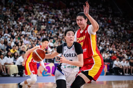 FIBA女子アジアカップ、韓国対中国戦での韓国代表パク・ジス選手が中国の長身センター張子宇選手をかわして攻め込む様子。