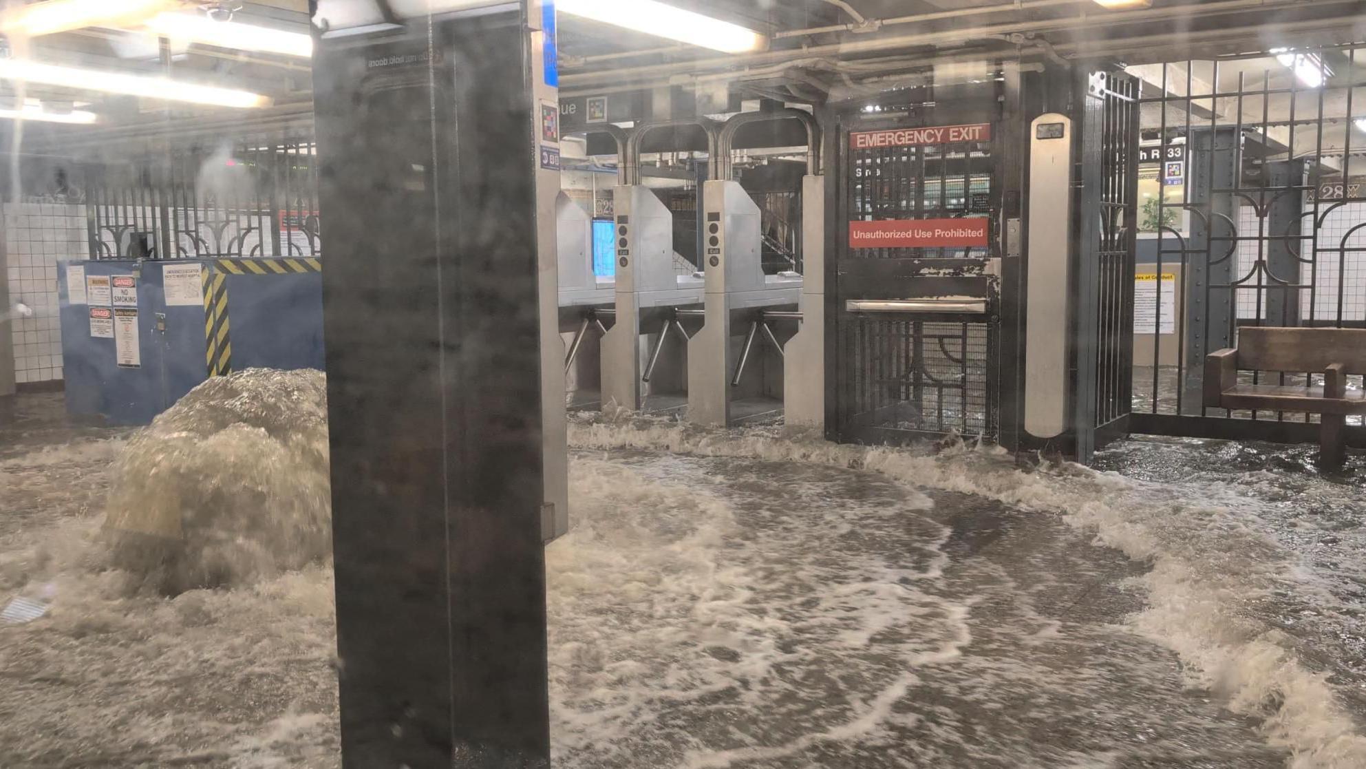 ニューヨーク市で豪雨により浸水した地下鉄駅構内。激しい鉄砲水が流れ込む様子を示す