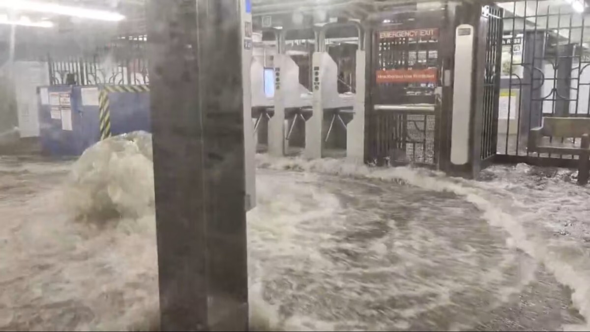 ニューヨーク市内の地下鉄駅の改札付近で洪水が発生し、水があふれ出す様子。米国東海岸の記録的豪雨による交通機関への影響を示す。