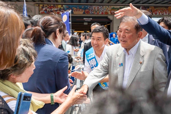大阪で支持者と握手する石破茂首相。参院選の応援演説に逆風が吹く中で活動を続ける様子。