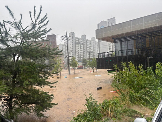 冠水した韓国・光州北区新安洞のスターバックス店舗内部。泥水に浸かり浮かぶ家具と避難した人々
