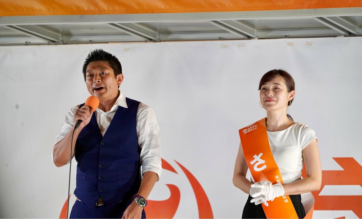 参議院選挙前夜、東京・芝公園での参政党最終演説会にて、マイクを握る神谷宗幣代表（左）と候補者のさや氏。