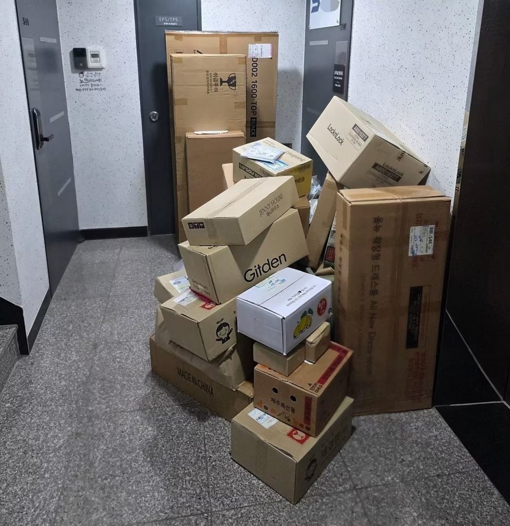 韓国マンションの共用廊下に山積みされた宅配便の箱