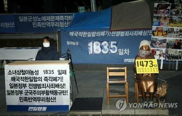 平和の少女像の横で座り込みを行う韓国の市民団体メンバー。ソウルの日本大使館前でのデモ活動の様子。