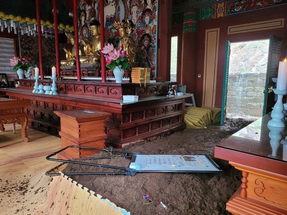 豪雨で土砂が押し寄せた山清の栗谷寺大雄殿の仏殿内部。