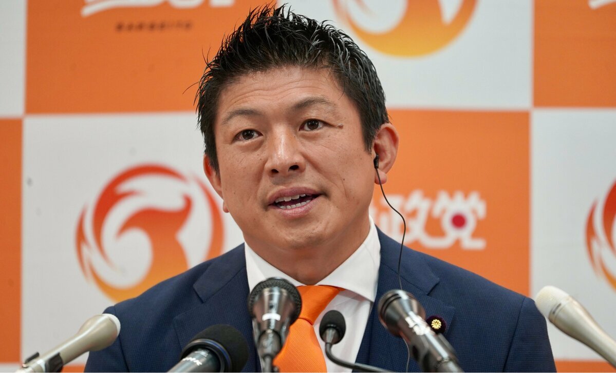 参議院選挙の開票センターで、参政党カラーのオレンジ色のネクタイを着用した神谷宗弊代表が報道陣の前に立つ姿