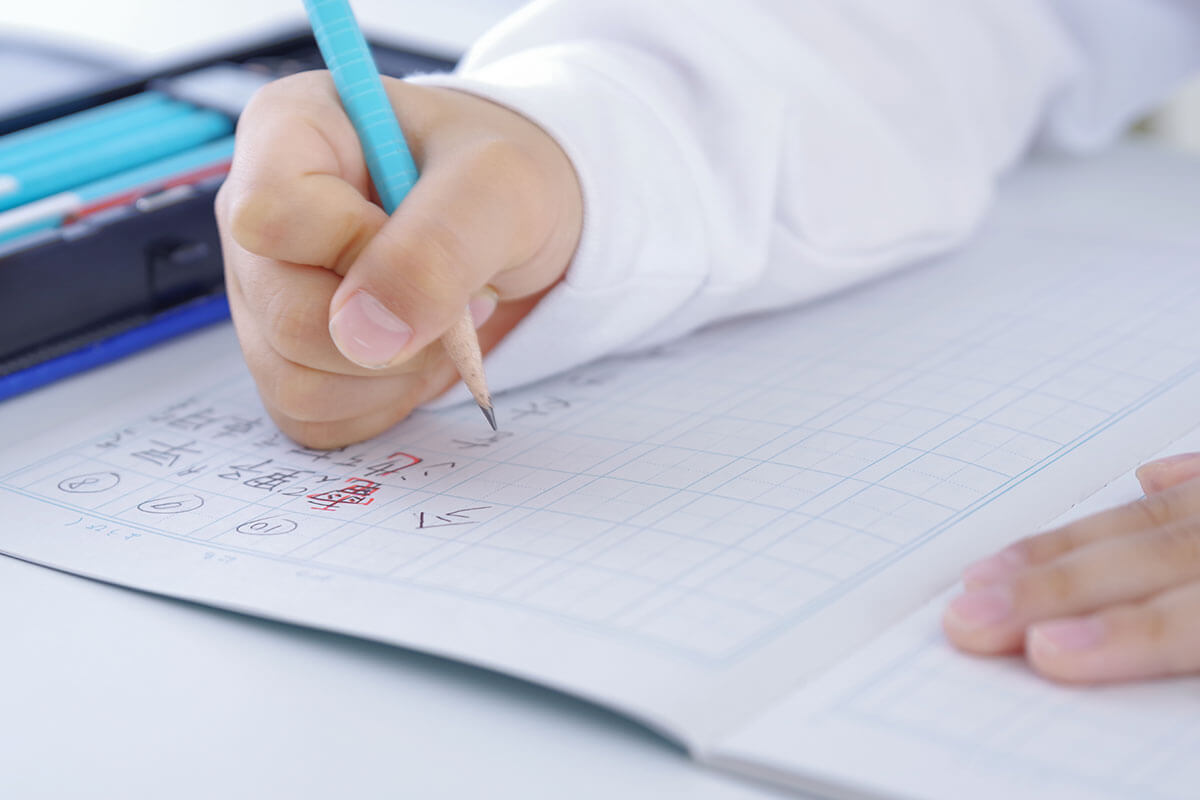 中学受験の夏期講習で学習のプレッシャーに直面し、疲弊した様子の小学生男子。