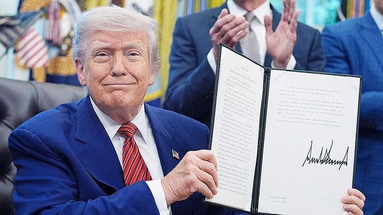 ドナルド・トランプ米大統領がホワイトハウスで署名済みの重要文書を示す。広範な関税政策と国際貿易における米国のスタンスを示す象徴的な光景。