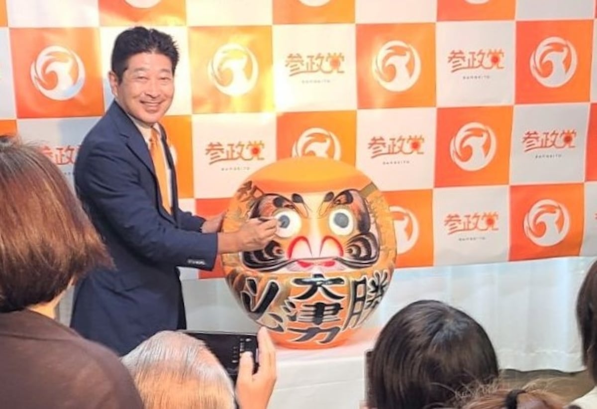 参政党の大津力氏が参院選当選後にだるまの目に筆を入れる様子。埼玉県飯能市で撮影。