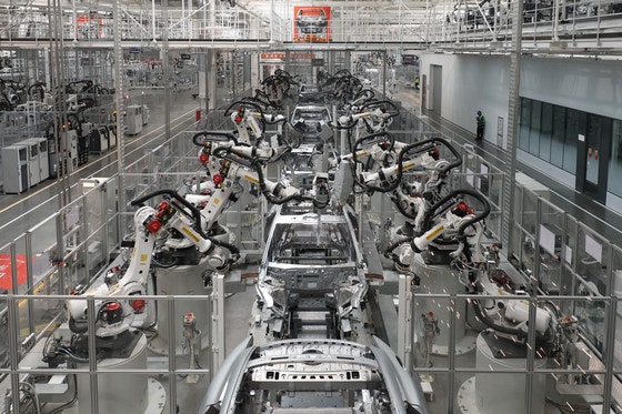 北京のシャオミ電気自動車スーパーファクトリーで車体を自動組み立てするロボットアーム