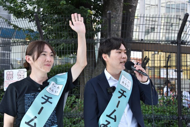 チームみらいの安野貴博氏と峰島侑也氏が新宿駅前で街頭演説を行う様子。2025参院選での政策重視の選挙活動を示す一枚。