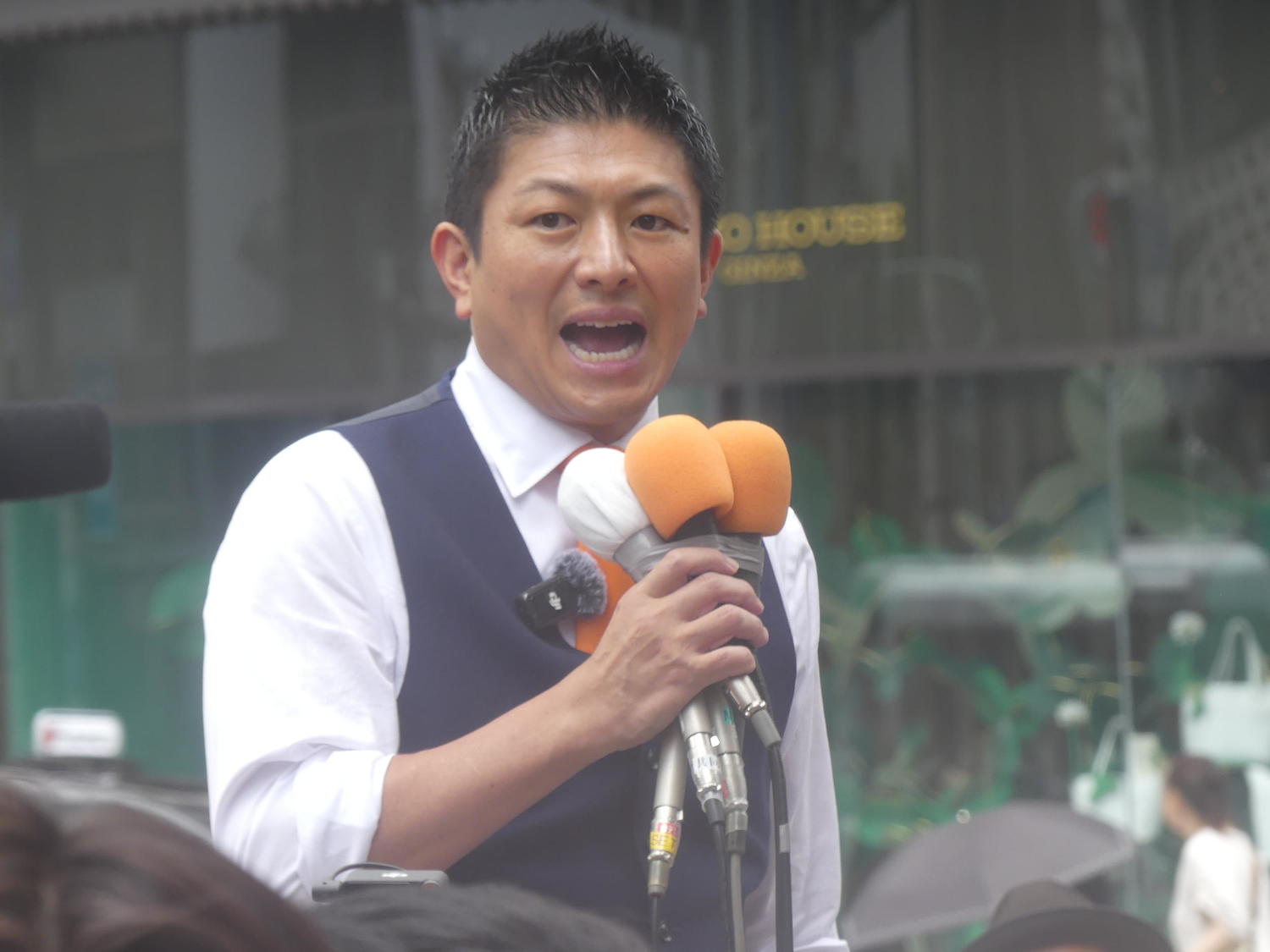 参政党の神谷宗幣代表がテレビ番組出演中に在日米軍に関する安全保障政策について説明する様子。
