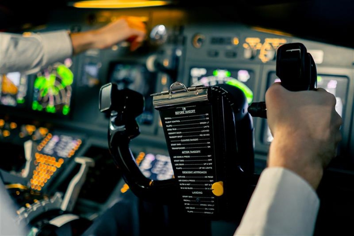 飛行機のコックピットで操縦桿を握るパイロット。航空機の安全と乗客の命は彼らの手に委ねられている。