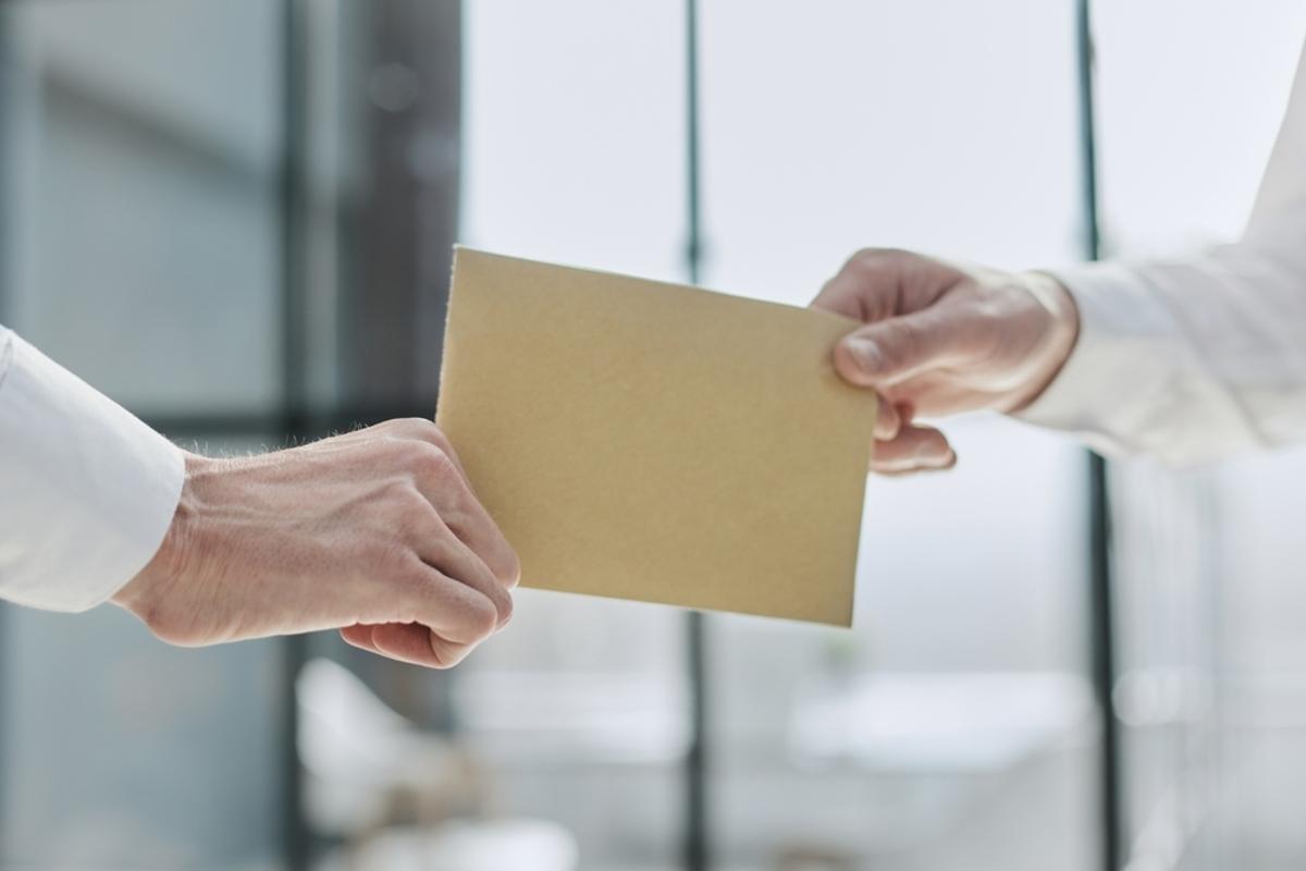 家族経営で手渡し給与を受け取る手元と確定申告の必要性を示すイメージ画像