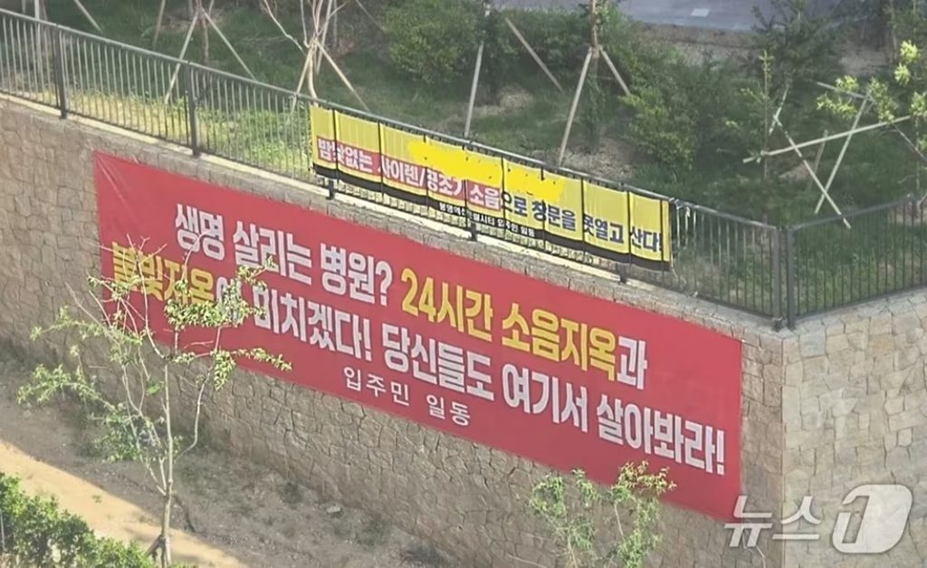 韓国忠清南道天安市で、隣接する大学病院に向けてマンション住民が掲げた騒音と光害への抗議横断幕。