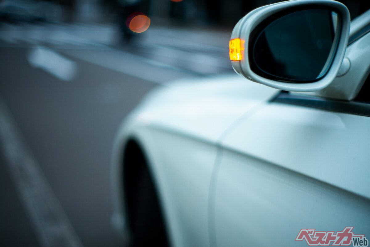 車の方向指示器（ウインカー）が点滅している様子。安全な車線変更や右左折のために重要な合図です。