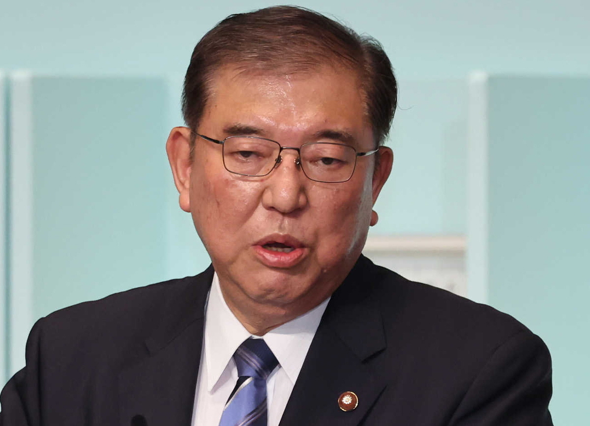 石破茂首相が両院議員懇談会でマイクを持って発言する様子