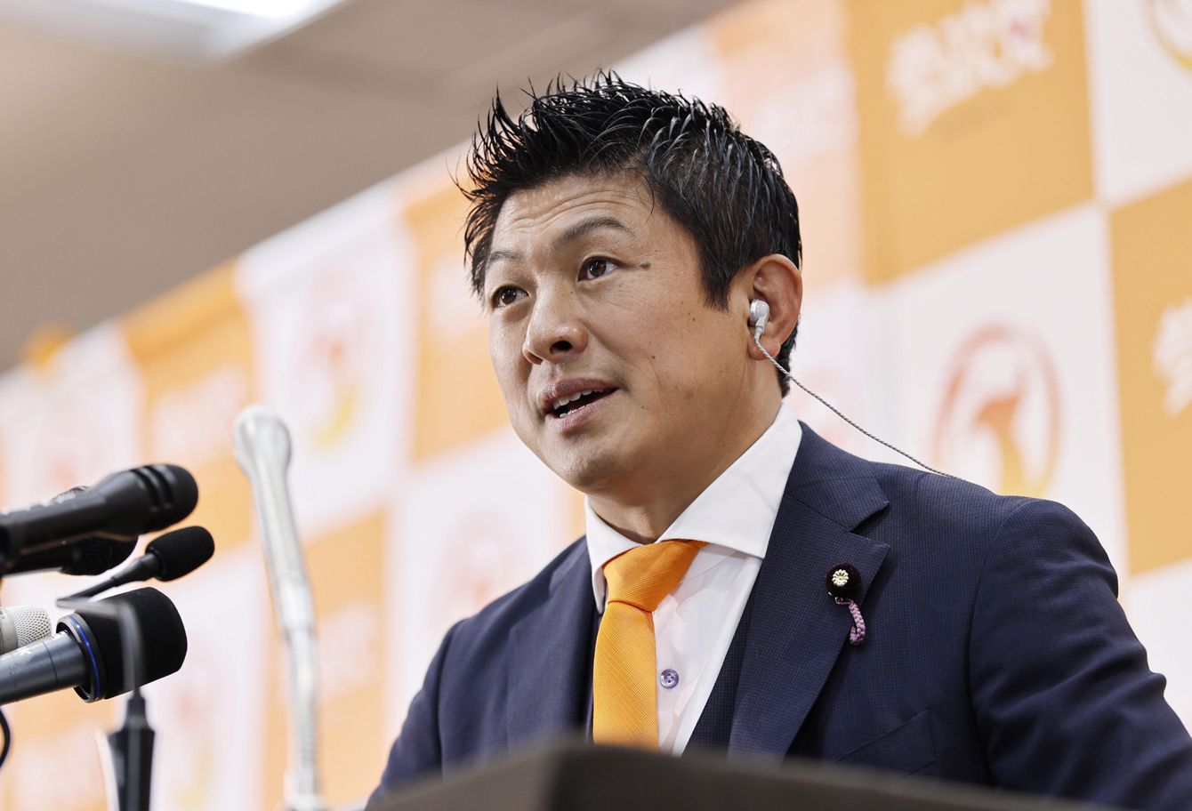 モノクロ写真でインタビューに答える参政党の神谷宗幣代表。参院選での躍進の立役者として、少子化対策など政策に関する自身の見解を述べている様子。