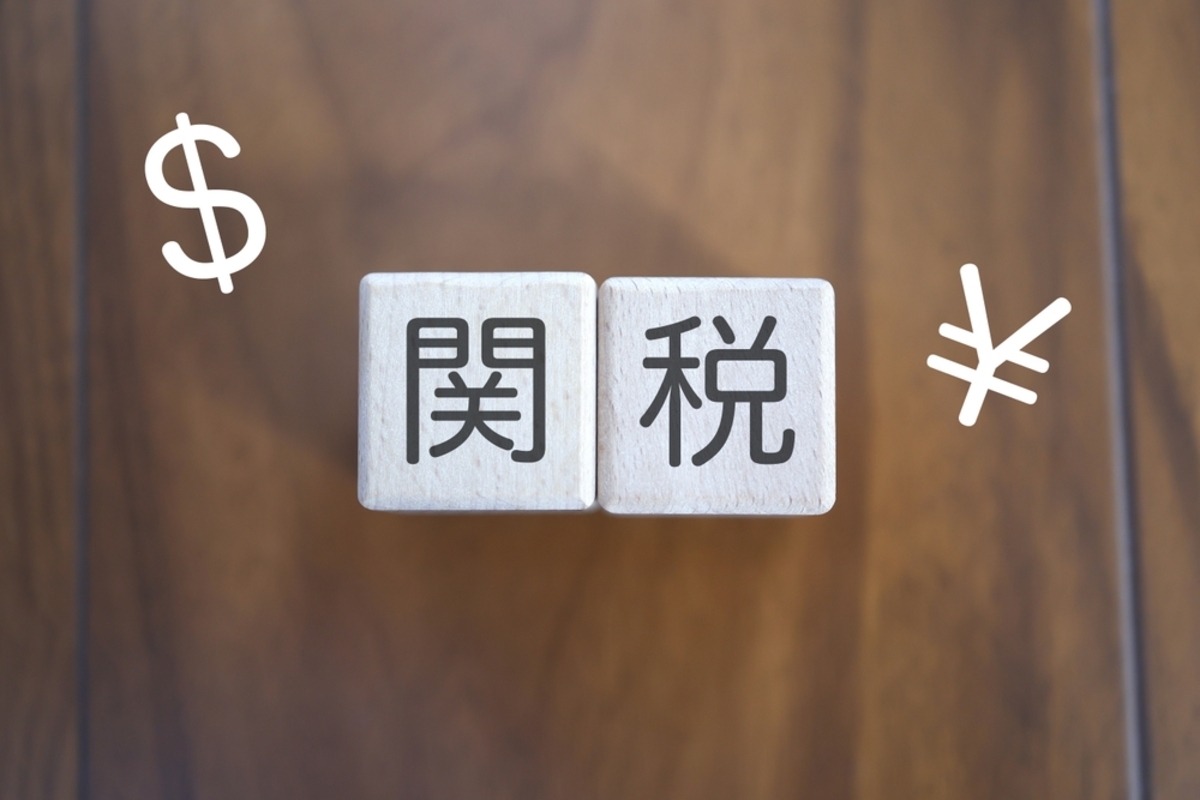 輸入品の価格に影響する関税引き下げを検討する消費者の手元に置かれた書類