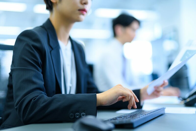 AIが生成した文章をPC画面で確認する人物。デジタルコミュニケーションにおけるAI利用の葛藤を示す。