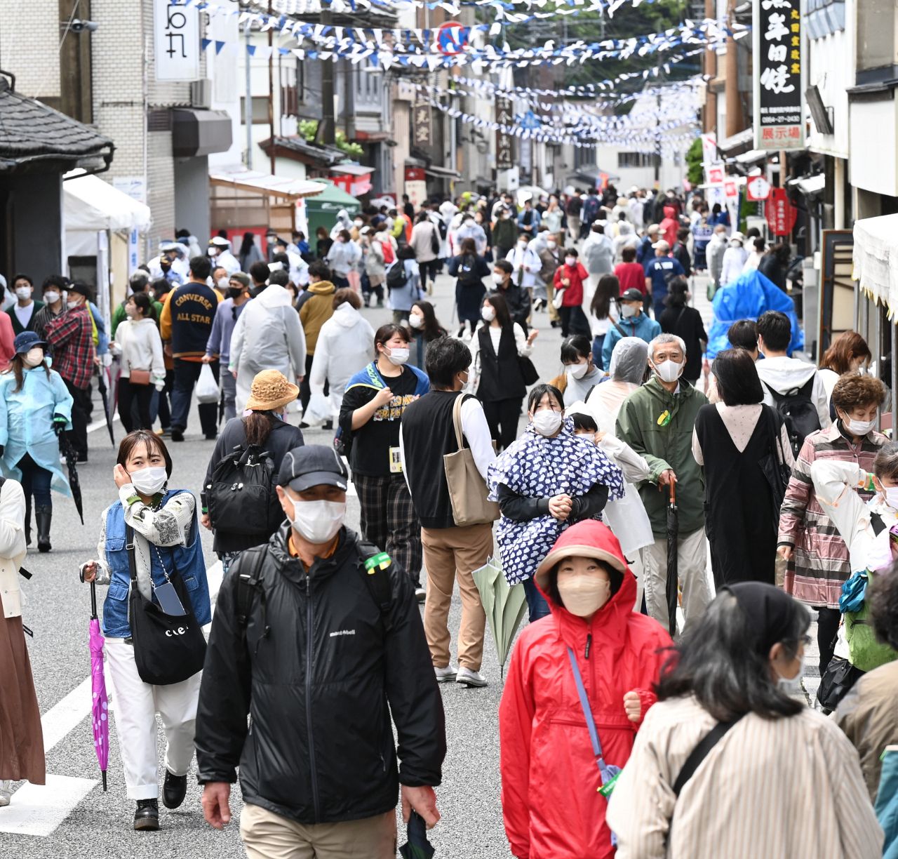多くの外国人観光客で賑わう日本の都市の街並み。インバウンド需要の増加とオーバーツーリズム問題を示すイメージ写真。