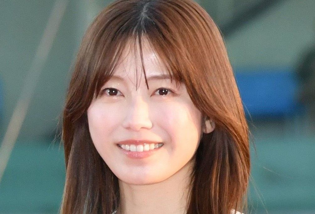 純烈・後上翔太と元AKB48・横山由依がテレビ番組「ザ・共通テン！」のセットを背景に寄り添い、幸せそうな笑顔を見せる貴重な夫婦ツーショット写真。二人の身長差が際立つ一枚。