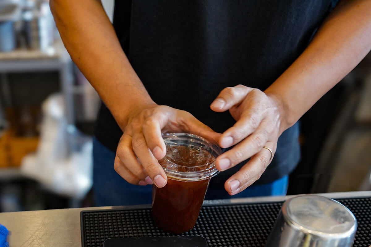 スターバックスのコーヒーを持つコンサルタントの姿、クライアントへの配慮を象徴