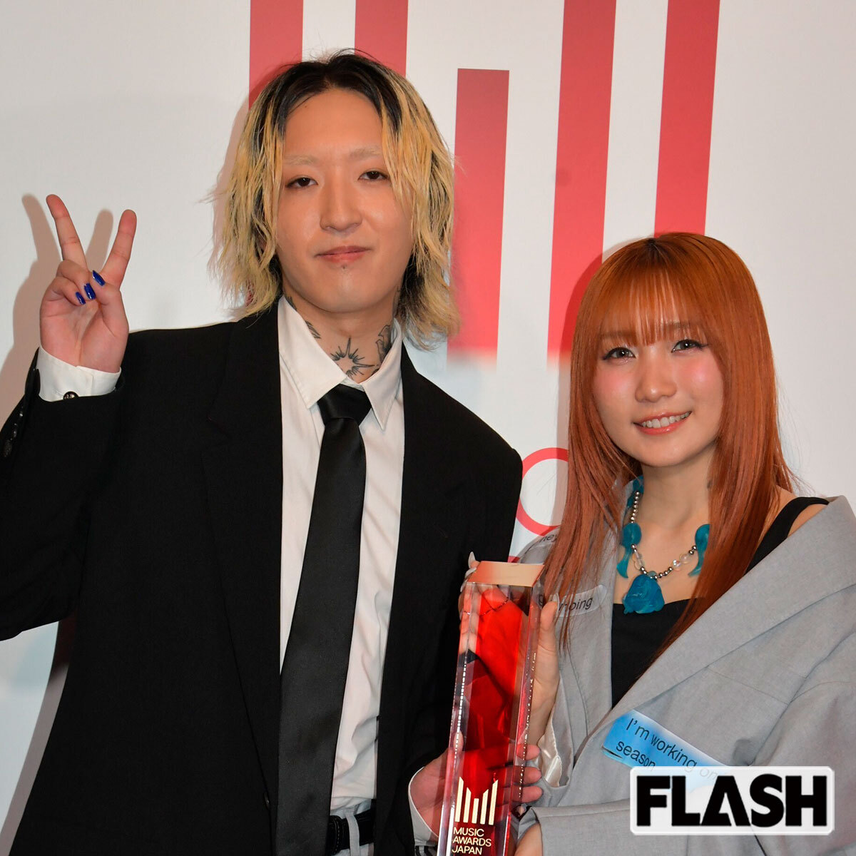 YOASOBIのコンポーザーAyaseとボーカルikuraが並ぶ写真、Ayaseの腕にはタトゥーがちらりと見える。