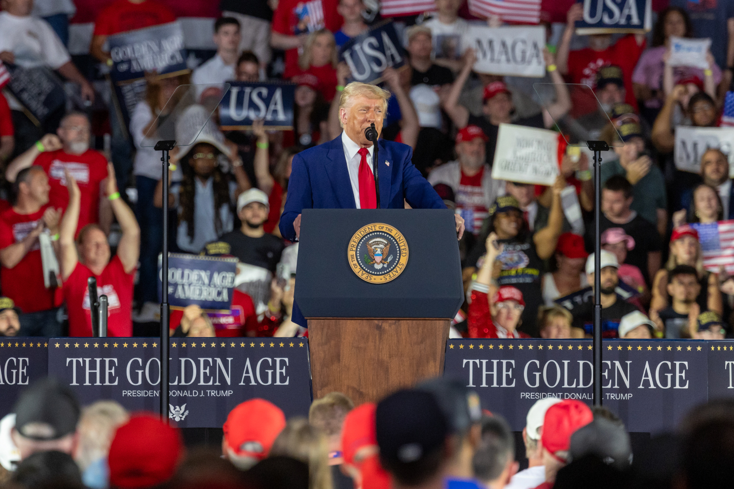 トランプ元大統領の選挙集会でMAGA帽を着用し、熱心に演説を聞く支持者たち。彼らの外交政策に対する見解が孤立主義的ではないことを示唆する調査結果が注目されている。