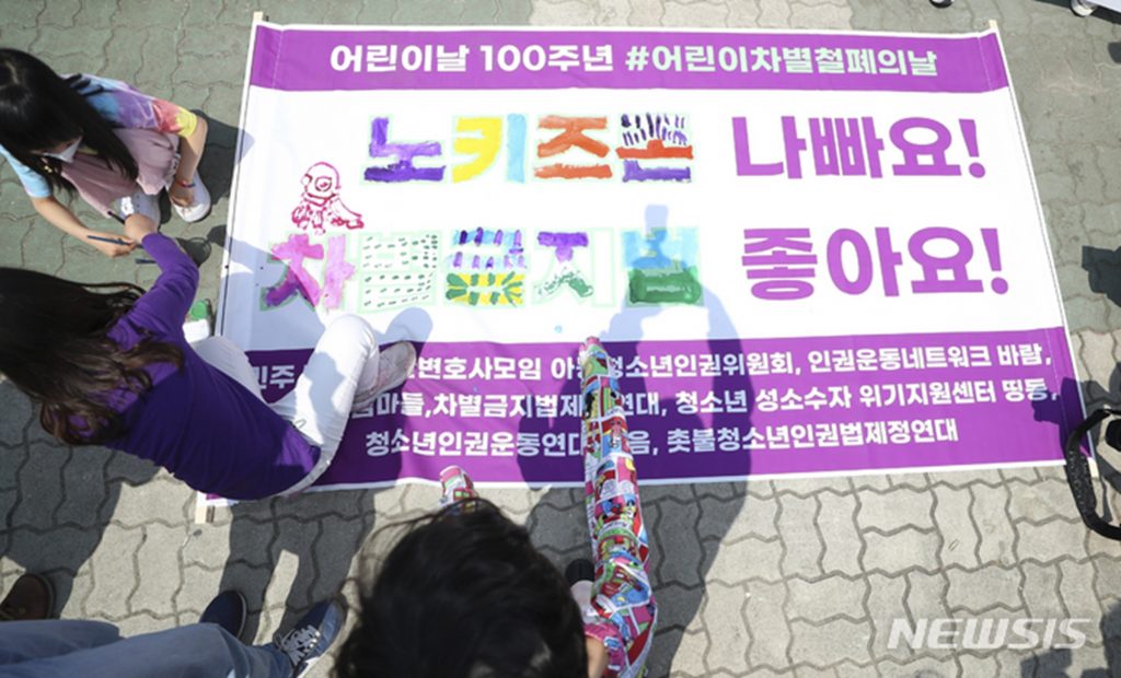 2022年、韓国で「ノーキッズゾーン反対」と書かれたメッセージを塗る子どもたち。社会的排除への意識を示す象徴的な光景。