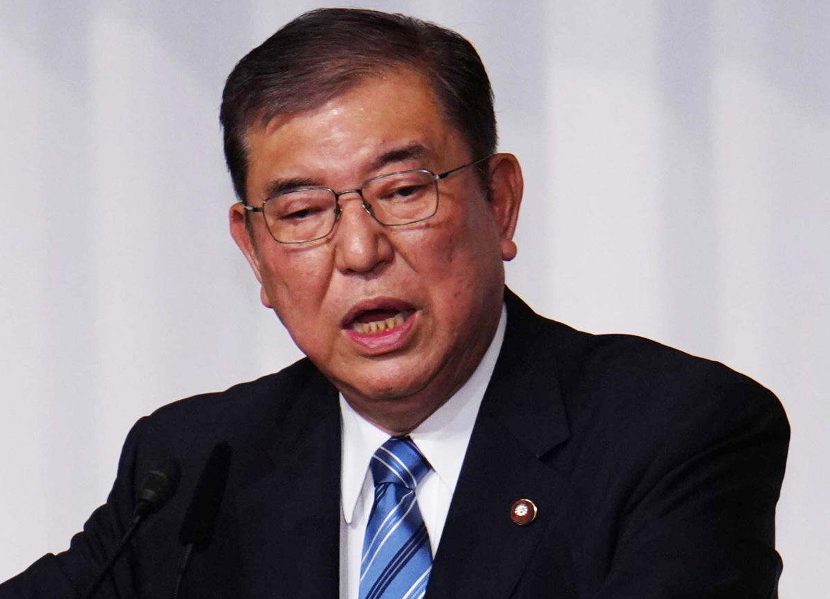 自民党の両院議員総会で演説する石破茂首相の隣で、複雑な表情を見せる森山裕幹事長。石破政権の命運を巡る党内抗争が続く中、両者の関係性が注目される。