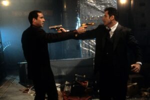 映画『フェイス／オフ』の象徴的な場面：ジョン・トラボルタとニコラス・ケイジの顔が交錯するアクションシーン