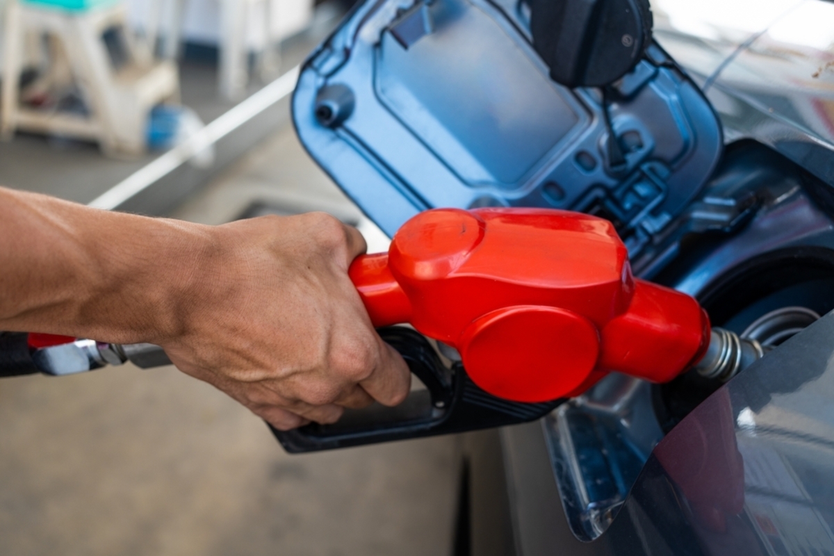 ガソリンスタンドで給油する車の様子。ガソリン税を含まない価格シミュレーションと家計への影響を示す。