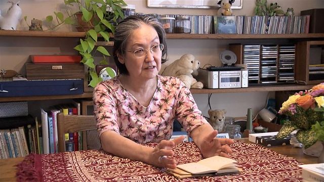 日本航空123便墜落事故で父を亡くした河口真理子さんが手帳を手に取材に応じる様子