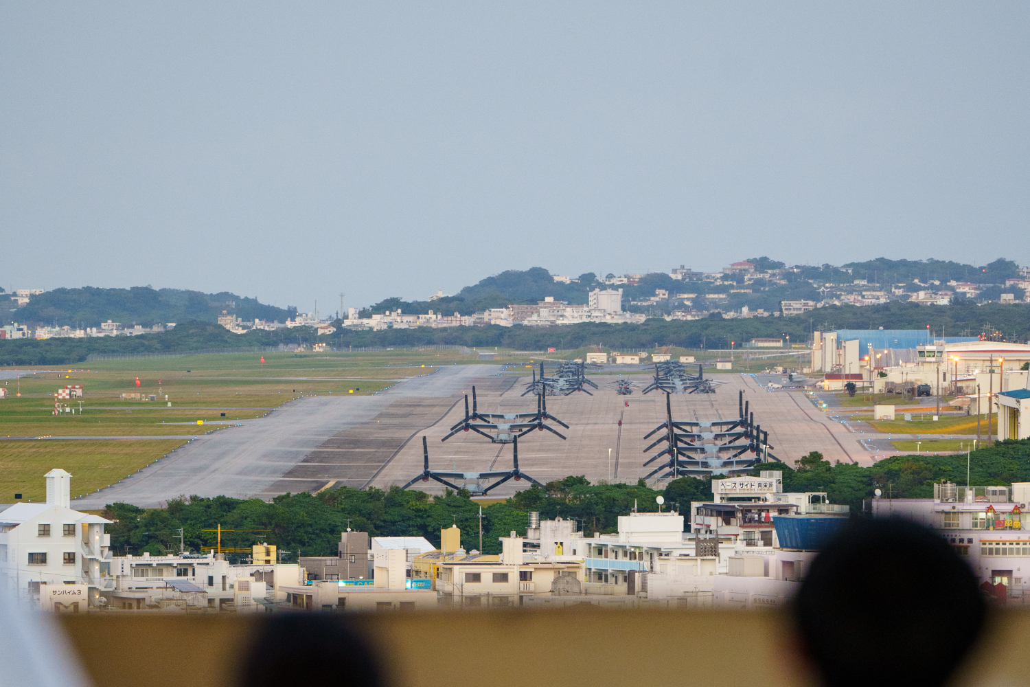 沖縄県宜野湾市に位置する米軍普天間飛行場と、隣接する住宅地。沖縄の基地問題と住民への影響を示す。