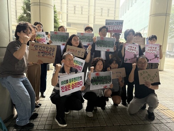ベトナム戦争民間人虐殺認定を求める人権団体活動家らが判決後に掲げるプラカード