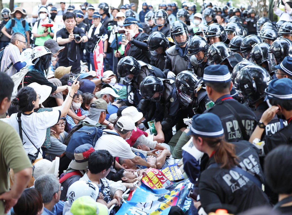 原爆ドーム前で集会参加者に退去を呼びかける広島県警機動隊員。平和記念式典前の緊迫した状況を示す。