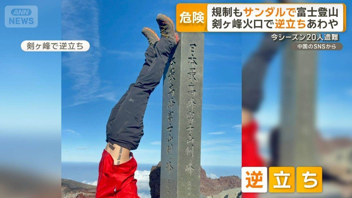 富士山頂の剣ヶ峰で逆立ちを行う男性の様子。富士登山におけるサンダルでの登山や危険な行為が問題視されています。