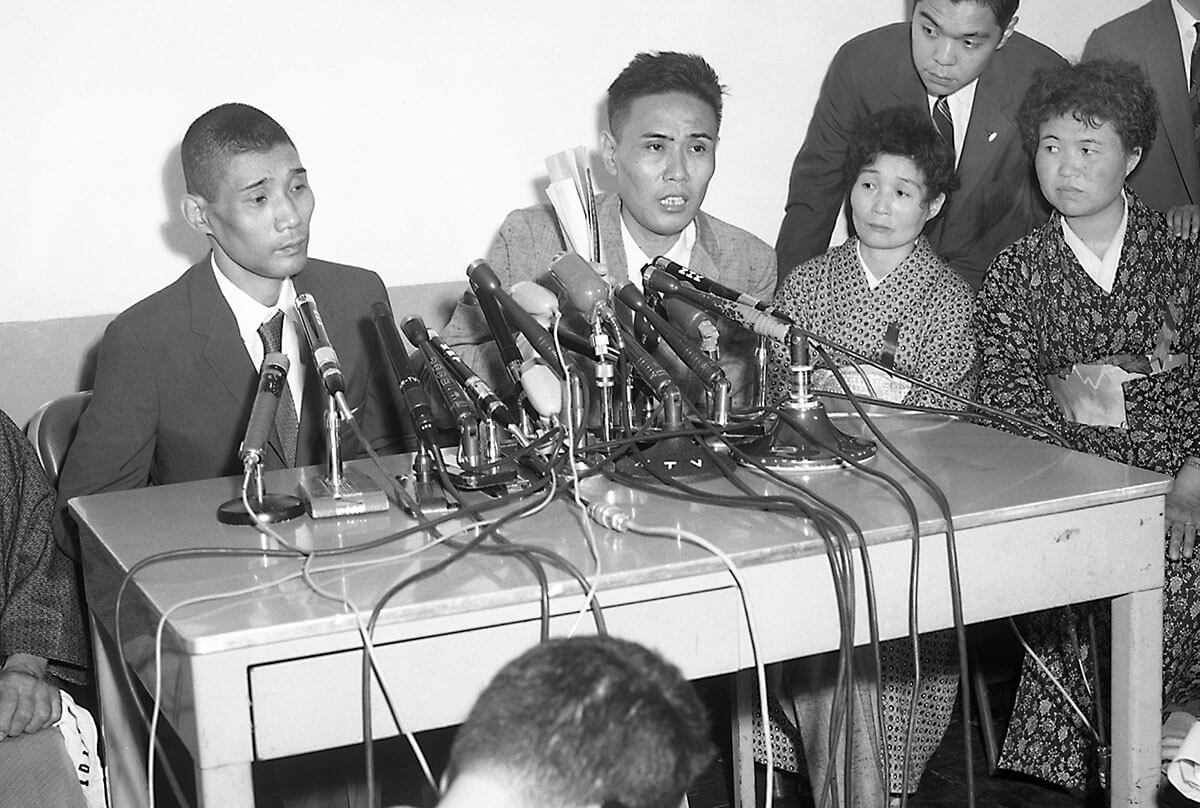 1960年、グアム島から帰還後、米軍立川基地で記者会見に臨む皆川文蔵氏（左）と伊藤正氏。残留日本兵としての16年間の生活を語る姿。