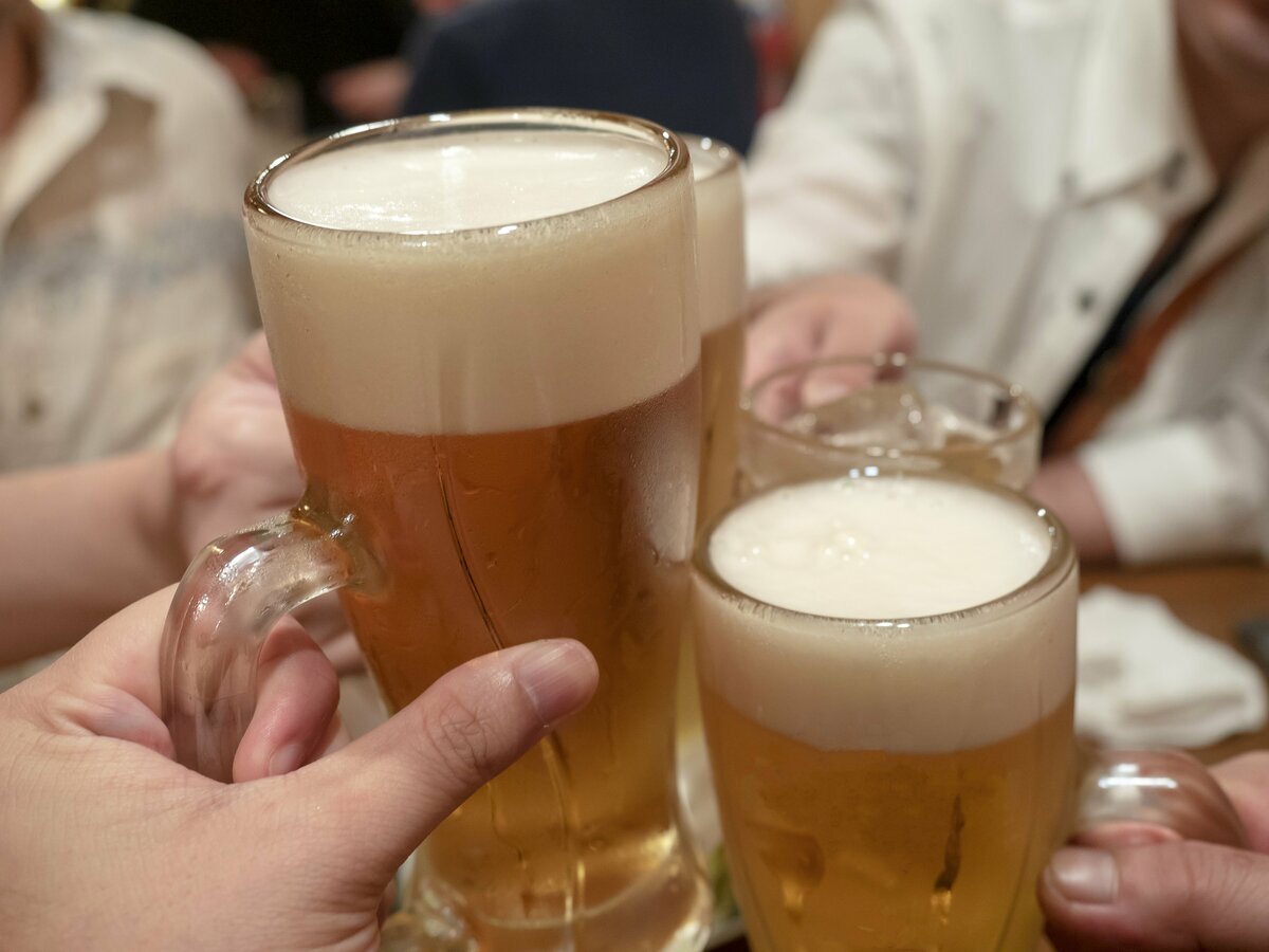 同窓会で旧友と再会し、笑顔で談笑する50代の男女