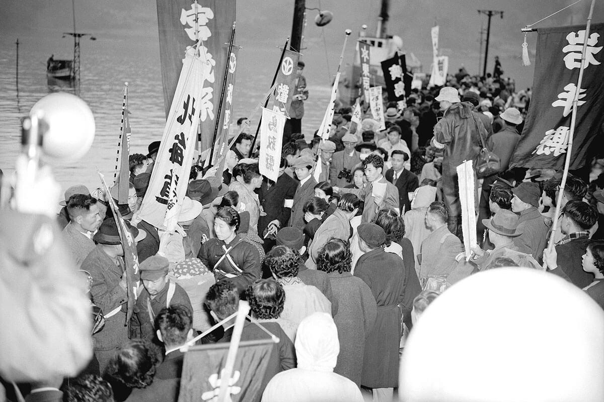 戦後の舞鶴港で、帰還した日本兵を迎える家族や市民たち。興安丸から降り立つ人々の姿は、多くの「戦死公報」が出た後も生きていた兵士たちの帰還を象徴する。