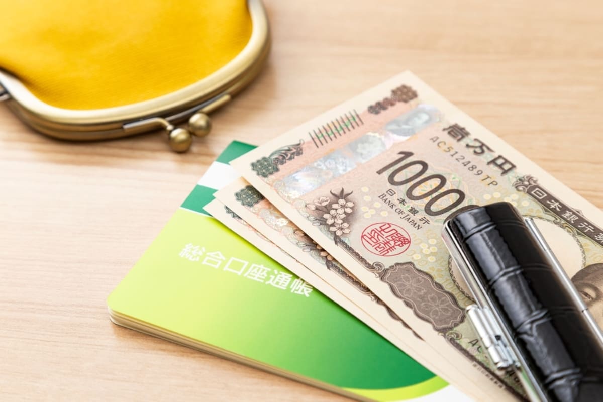 親が成人した子どもに貯金の通帳を渡す様子。贈与税の基礎知識と注意点。