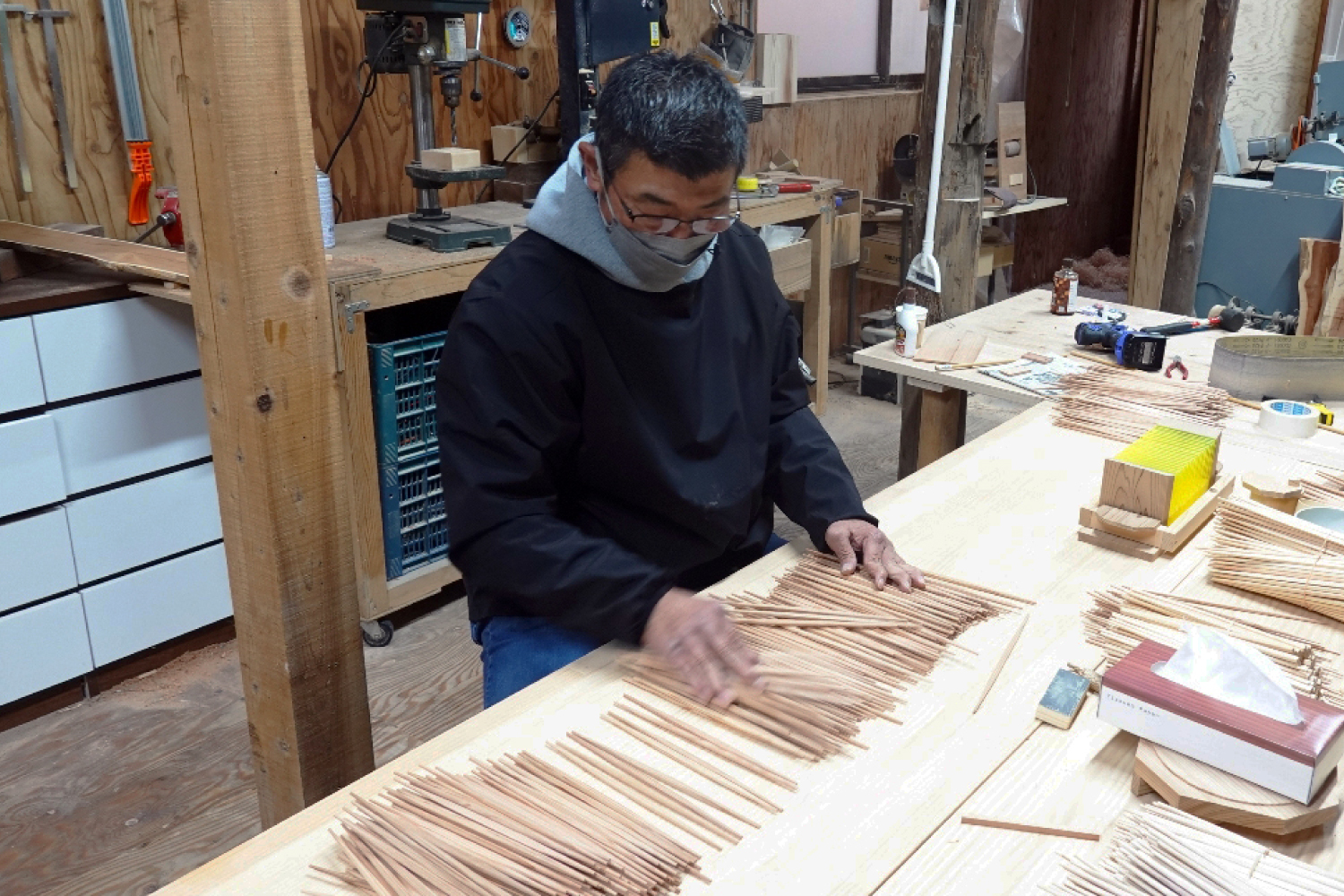 吉野杉割り箸の製造工程における最終検品の様子。職人が一本一本丁寧に品質をチェックしている。