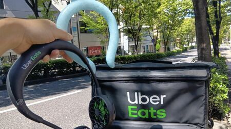猛暑の中、荷物を背負って立ち尽くすフードデリバリー配達員。自己防衛の必要性を訴える