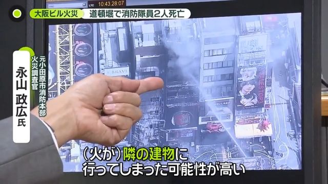 夜間も消火活動が続く道頓堀の火元ビル入口と消防隊員
