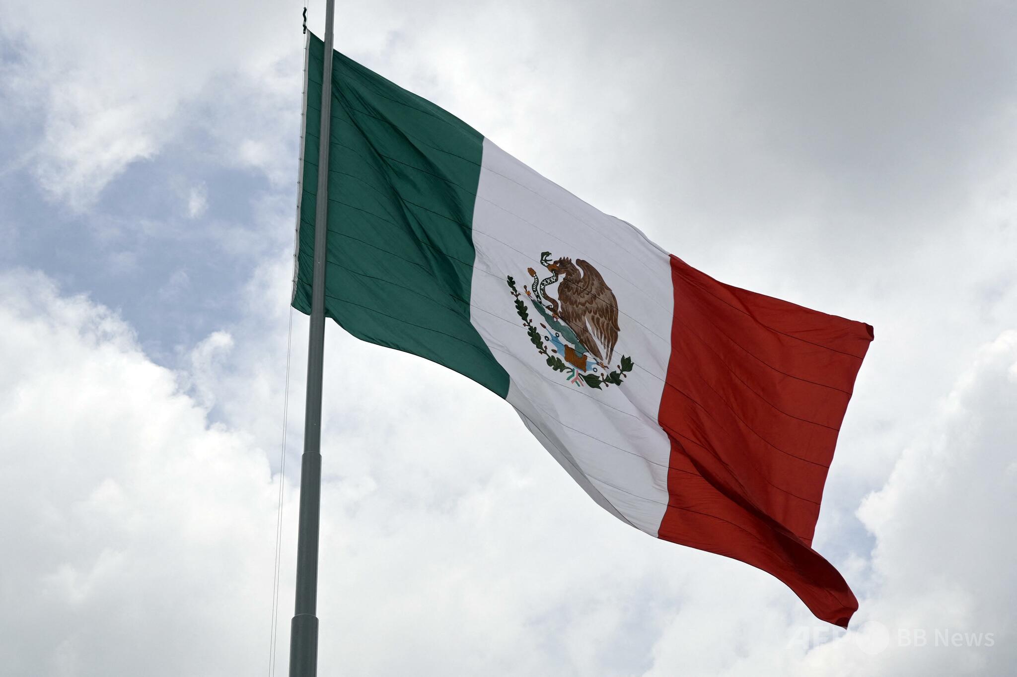 メキシコ市のソカロ広場に掲げられたメキシコ国旗。国内の治安問題と麻薬カルテル関連の暴力が深刻化する情勢を象徴する一枚。