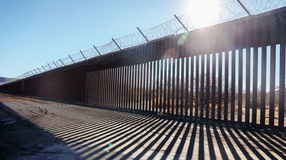 米国・メキシコ国境に立つ、黒色化が指示された壁。不法移民対策の象徴。