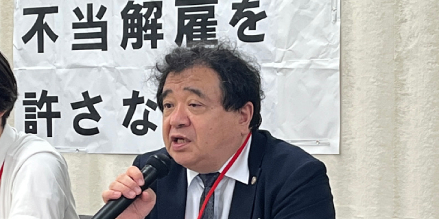 記者会見で発言する原告代理人の指宿昭一弁護士