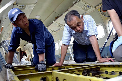 航空科学博物館でYS-11試作1号機の床下を調査する専門家。航空技術の専門家がYS-11の保存状態を詳細に確認。
